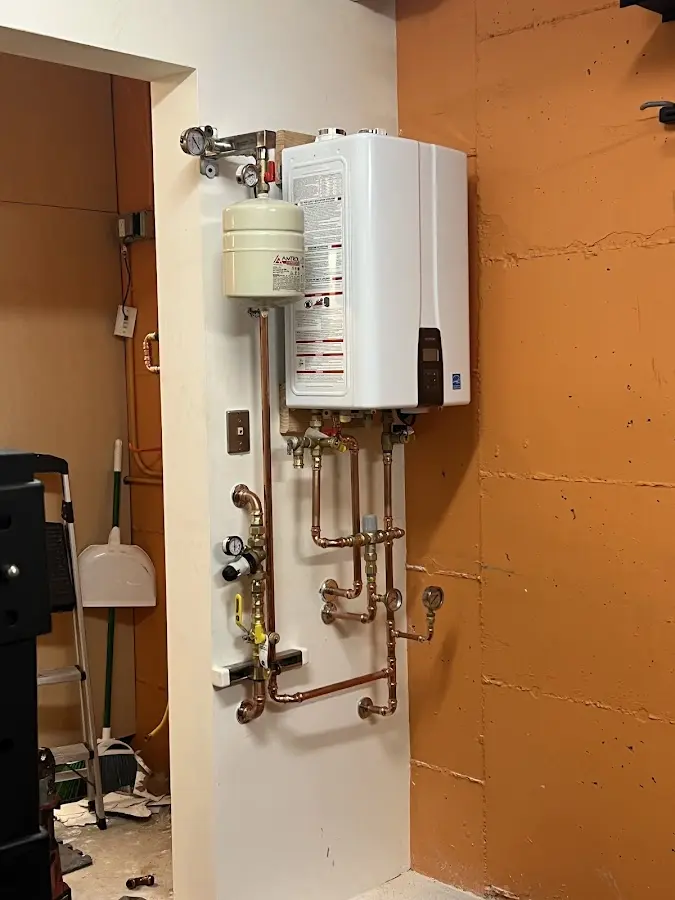 Plumbing technician inspecting water heater connections in Old Lyme